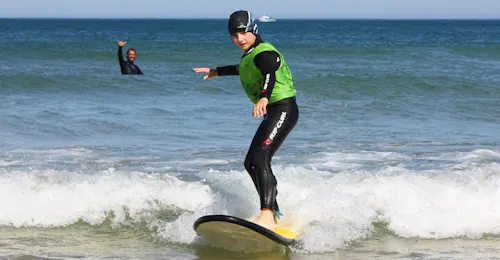 Cours de surf Enfants (6-8 ans) sur la plage Sud à Messanges avec Messanges Surf School Un enfant surfe ses premières vagues grâce à son Cours de surf Enfants (6-8 ans) sur la plage Sud à Messanges avec Messanges Surf School.