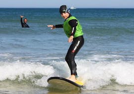 Ein Kind surft seine ersten Wellen dank des Surfunterrichts für Kinder (6-8 Jahre) am Messanges South Beach mit der Messanges Surf School.