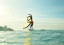 Un homme fait des Cours de wingfoil sur la plage de l'Almanarre à Hyères avec Spin Out. 