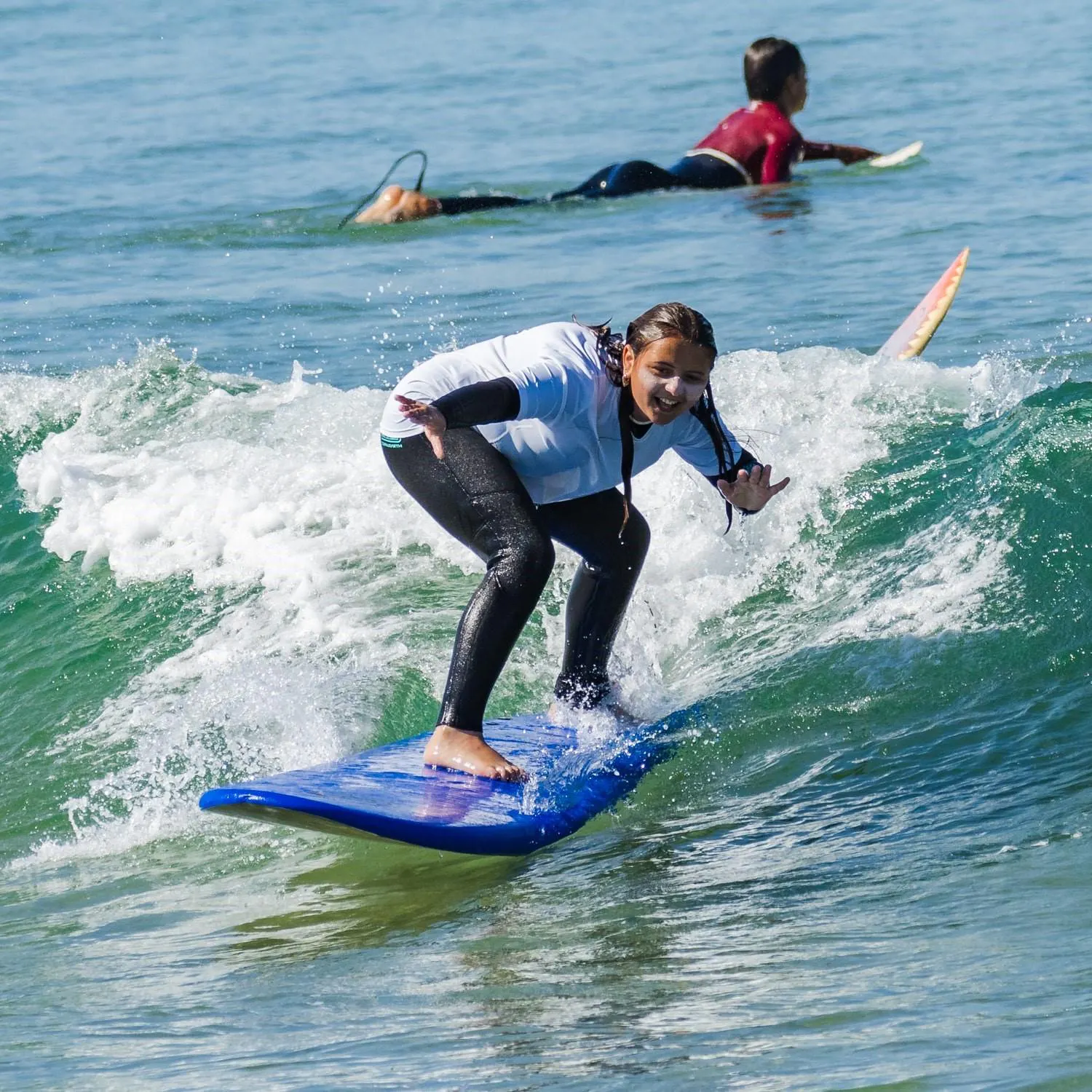 Cours semi-privé de surf sur la plage de Costa da Caparica avec Gecko Surf School Costa da Caparica Une jeune fille de l'école de surf Gecko Surf School surfe sur la Costa da Caparica.