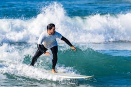 Ein junger Mann von der Gecko Surf Schule surft an der Costa da Caparica.