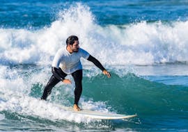 A young man from the Gecko Surf School surfs on the Costa da Caparica.