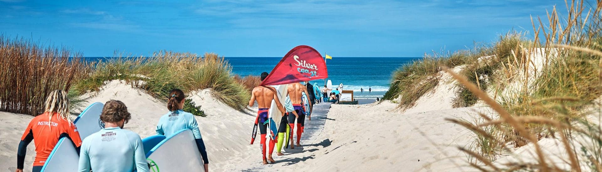 Eine Gruppe nimmt an Surfstunden mit der Silver Coast Surfschule in Peniche teil.