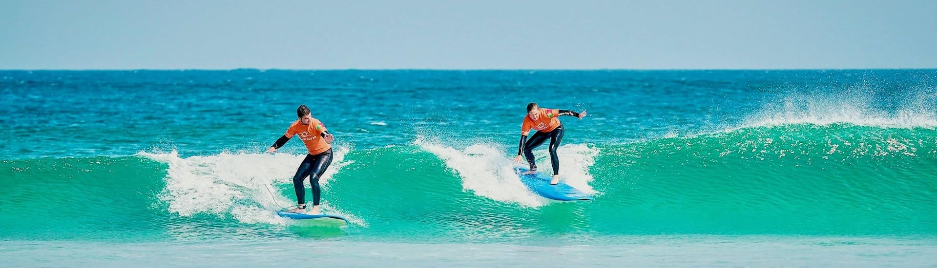 Two friends are enjoying a private surfing lesson on Cova da Alfarroba in Peniche with Special Surf 78.