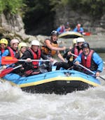 A group of rafters is paddling along the river during their Half-Day Rafting on the Salzach River in Taxenbach with Rafting Center Taxenbach.