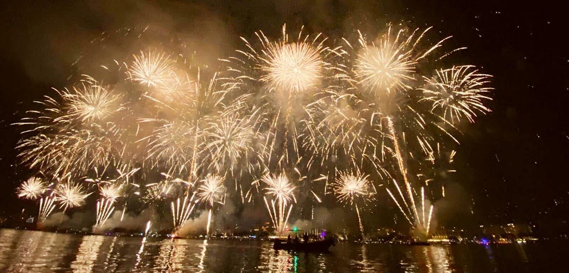 Persone che guardano un fuoco d'artificio durante la gita in barca da Cannes con spettacolo pirotecnico con i Black Tenders.