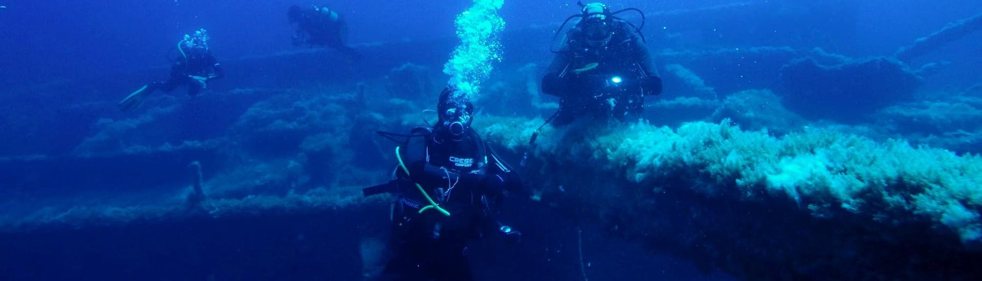 Divers are posing in front of a wreck during a guided dives for certified divers to Othoni Island with Dive Easy.
