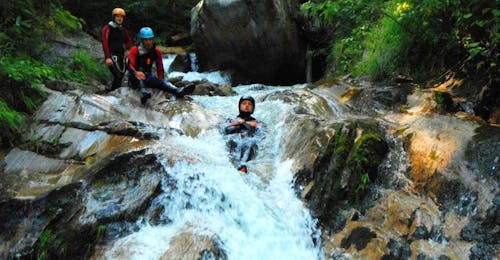 Makkelijk Canyonen in het Mölltal bij Obervellach voor Gezinnen met Sporterlebnis Camp Pristavec Obervellach Een man van de Sporterlebnis Camp Pristavec Obervellach glijdt tijdens het canyoning van een waterval.