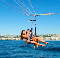 Two girls are having fun while parasailing in the baie des anges with Nikaia Watersports in Nice.