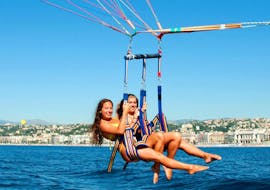 Two girls are having fun while parasailing in the baie des anges with Nikaia Watersports in Nice. 