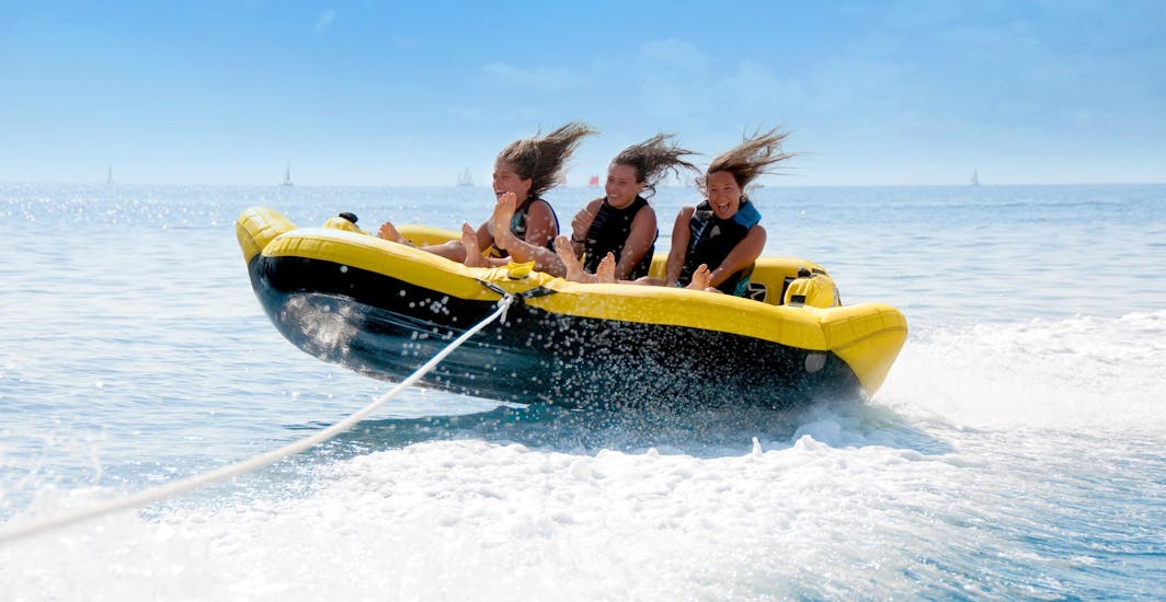 Trois jeunes filles s'amusent comme des folles sur une bouée gonflable dans la Baie des Anges avec Nikaïa Watersports à Nice.