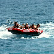 A group of friend is laughing on a towable tube in the Baie des Anges thanks to Nikaia Watersports in Nice.