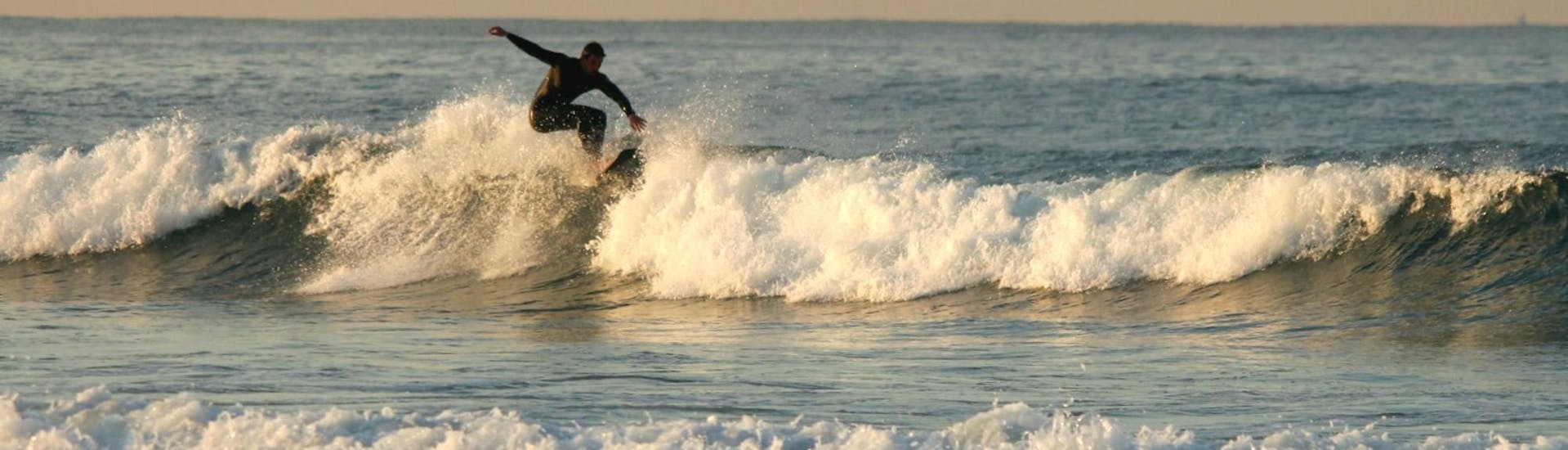 Un homme glisse sur une vague durant un  cours privé de surf sur la plage de Matosinhos près de Porto avec Fish Surf School.