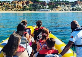 A group of people in a Nauticdrive boat on their tour to the Benagil cave in front of Praia da Rocha beach.