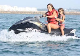 Una mujer y una niña en una moto de agua Nauticdrive en el océano Atlántico, cerca de Praia da Rocha. 