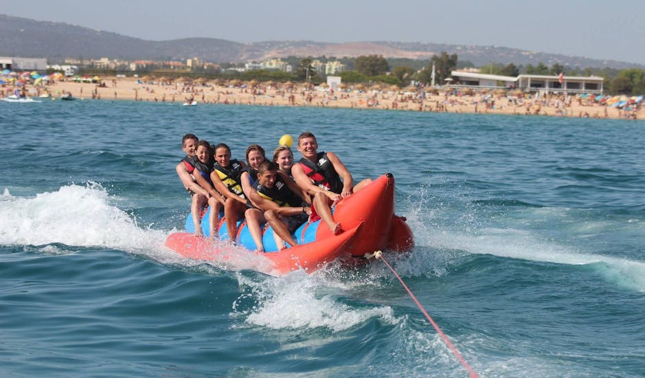Una familia se divierte en el mar durante un Bananaboat y más en la Praia da Rocha Baixinha con Nauticdrive Praia da Rocha Baixinha.