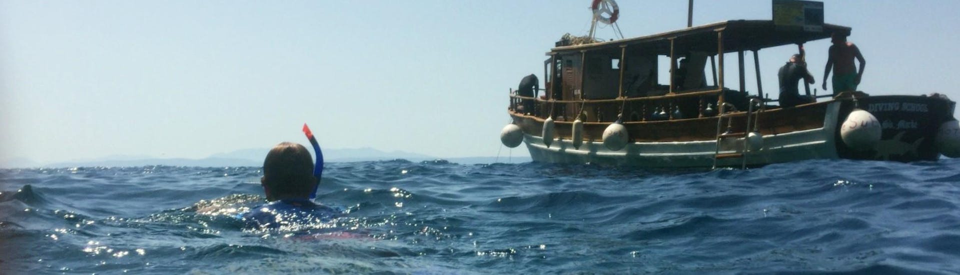 Ein Schnorchler schwimmt während eines Schnorchelausflugs an der Makarska Riviera mit More Sub Makarska Padi Dive Resort auf das Boot zu. 