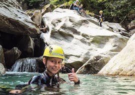 A girl is swimming in the clear water of the gorge during her Canyoning for Kids & Teens in Zemmschlucht - Jump & Run with Mountain Sports Mayrhofen.