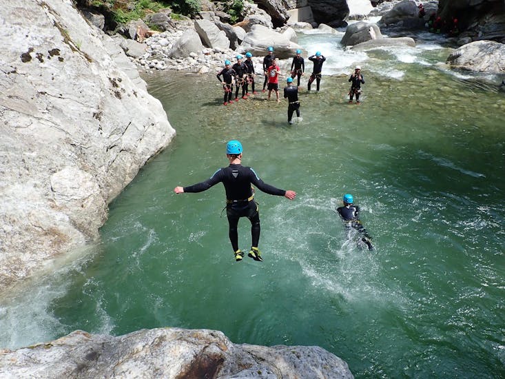 A participant of the Canyoning for Kids & Teens in Zemmschlucht - Jump & Run with Mountain Sports Mayrhofen is taking a jump into a natural pool.