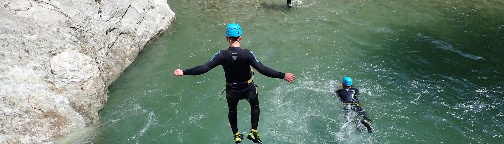 A participant of the Canyoning for Kids & Teens in Zemmschlucht - Jump & Run with Mountain Sports Mayrhofen is taking a jump into a natural pool.