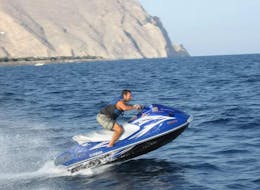 Un uomo cavalca una moto d'acqua ad Agios Georgios a Santorini, noleggiata da Crazy Sports Santorini.