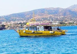 The catamaran from Creta Semi-Submarine is cruisisng across the sea off the port of Agios Nikolaos in Crete.