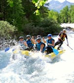 A group is splashed by the foam during an adventurous rafting tour on the Guisane river with Piraft Rafting Serre-Chevalier.