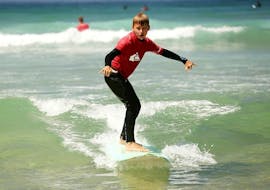 A young boy is enjoying his surf lesson for kids near Lagos with Tiny Whale Surf Lodge. 