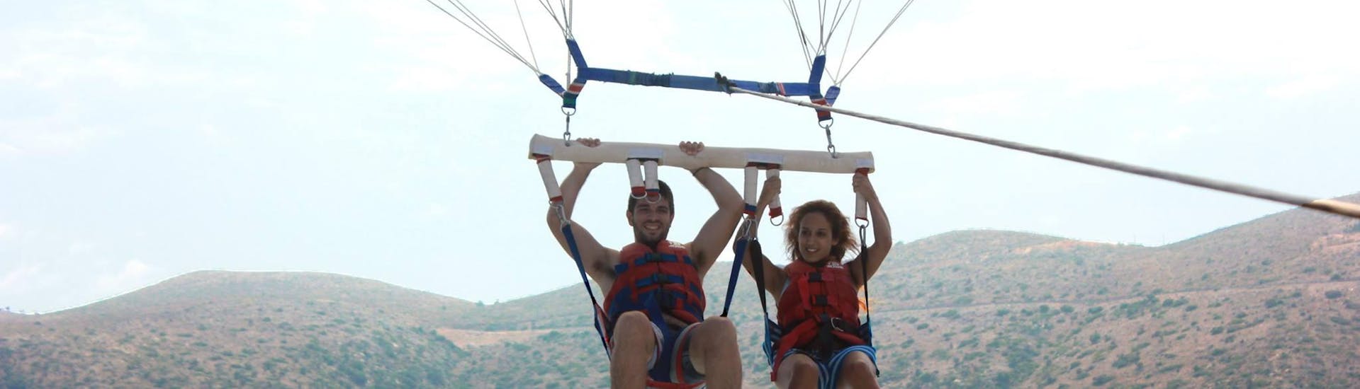 A couple is doing Parasailing in Stalida in Crete with Slalom Water Sports. 