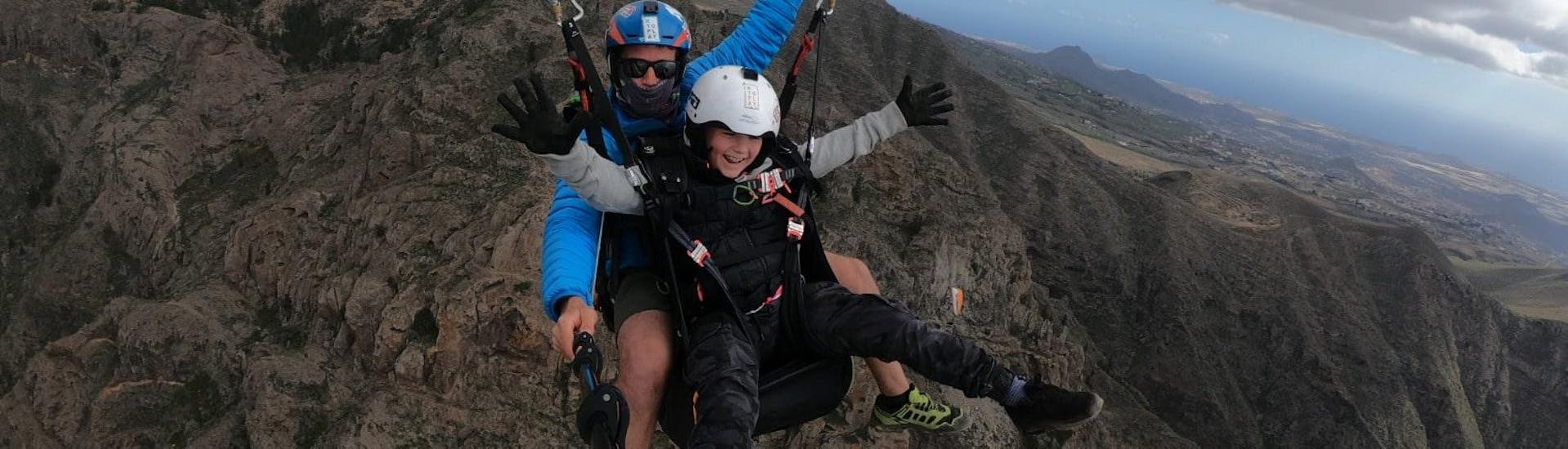 Un enfant et un moniteur effectuent vol tandem parapente panoramique à Costa Adeje avec Tenerife Top Paragliding.