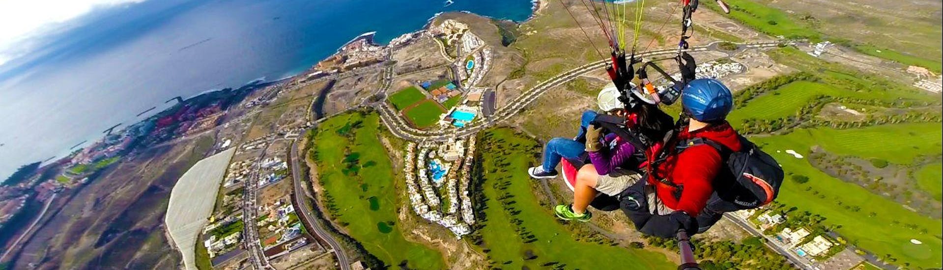 Zwei Personen machen einen Tandem-Gleitschirmflug in Costa Adeje mit Tenerife Top Paragliding. 