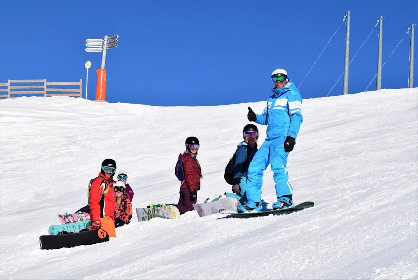 Des snowboardeurs font une pause au milieu d'une piste pendant leur cours particulier de snowboard (dès 10 ans) avec l'école de ski 360 Morzine.