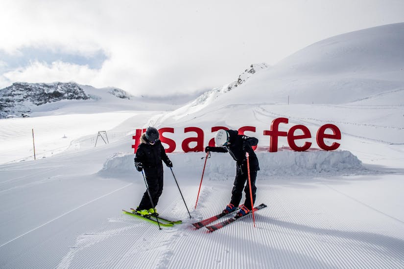2 adults are having fun during private ski lessons for adults for experts with Ski School Zenit Saas-Fee.