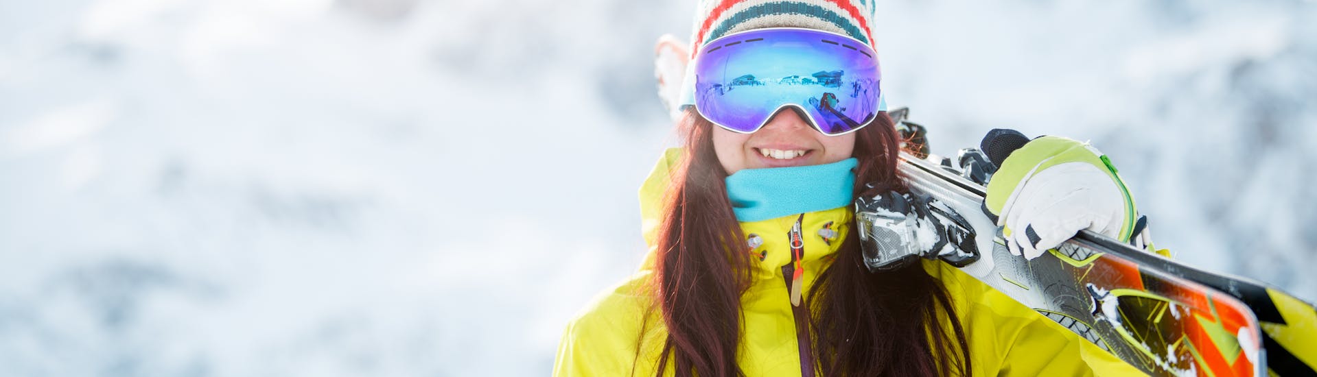 Een meisje lacht terwijl ze haar ski's draagt tijdens haar Skilessen voor Tieners (12-15 jaar) voor Gevorderde Skiërs met Family Ski School GO! Bad Gastein. 