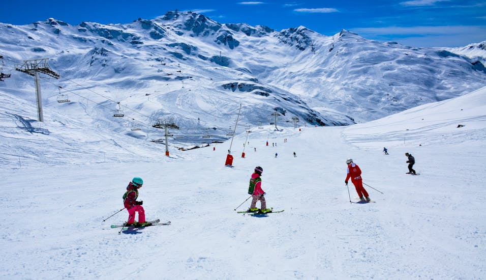 Tijdens een Super 6 kinderskiles van ESF Val Thorens dalen jonge skiërs samen met hun instructeur een helling af.