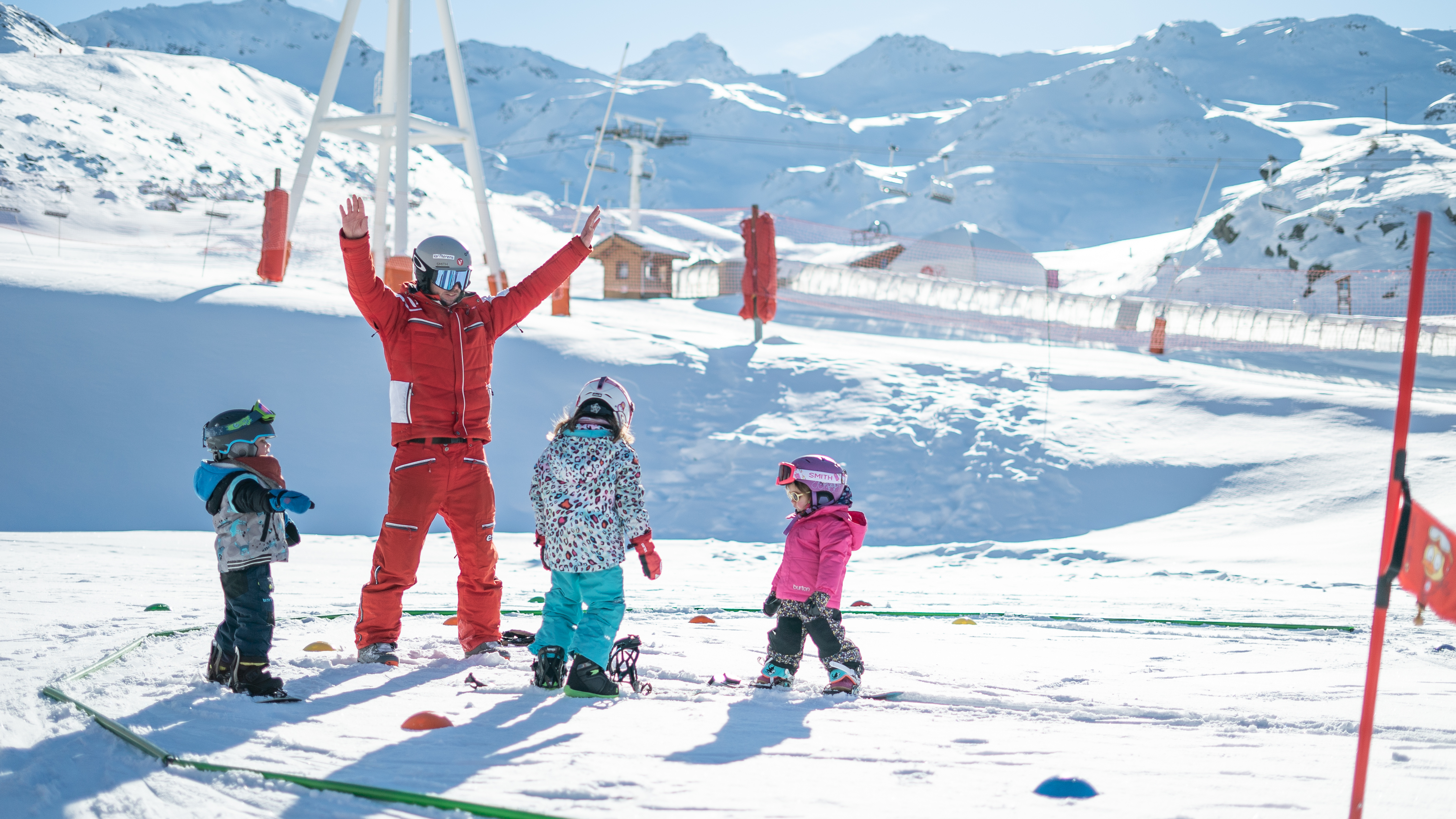 An instructor from ESF Val Thorens explains the basics of snowboarding during a snwoboarding lesson for kids for first timers. 