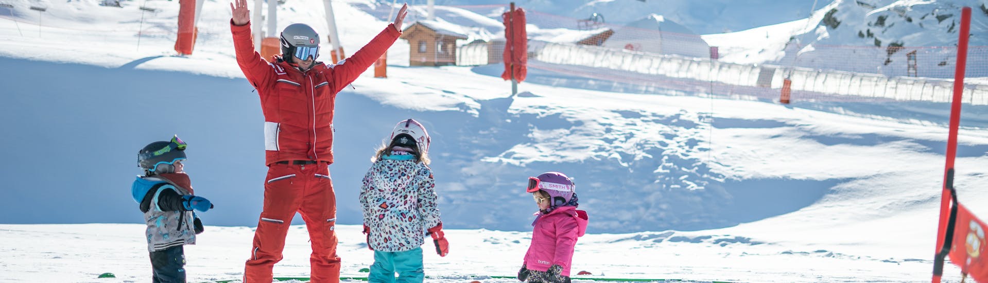 An instructor from ESF Val Thorens explains the basics of snowboarding during a snwoboarding lesson for kids for first timers. 