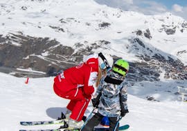Een instructeur van ESF Val Thorens ondersteunt haar leerling tijdens een privé skiles voor kinderen.