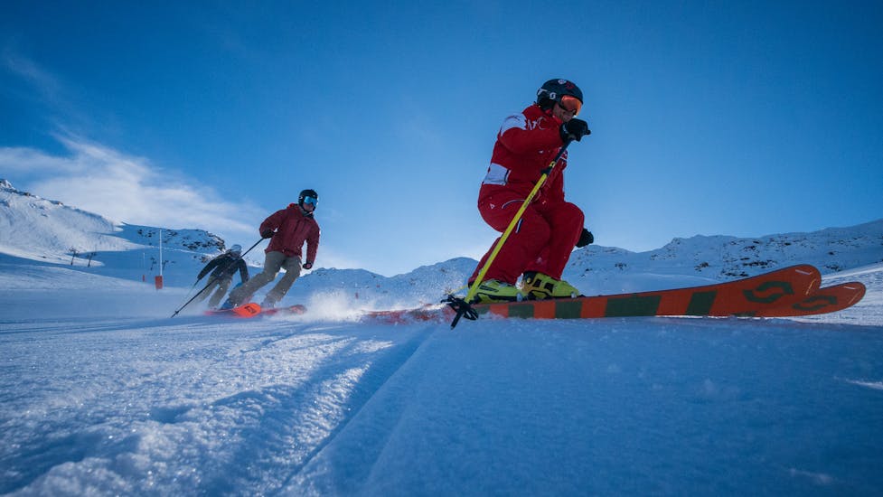 Des skieurs suivent leur moniteur sur les pistes lors d'un cours particulier de ski pour adultes de l'ESF Val Thorens.