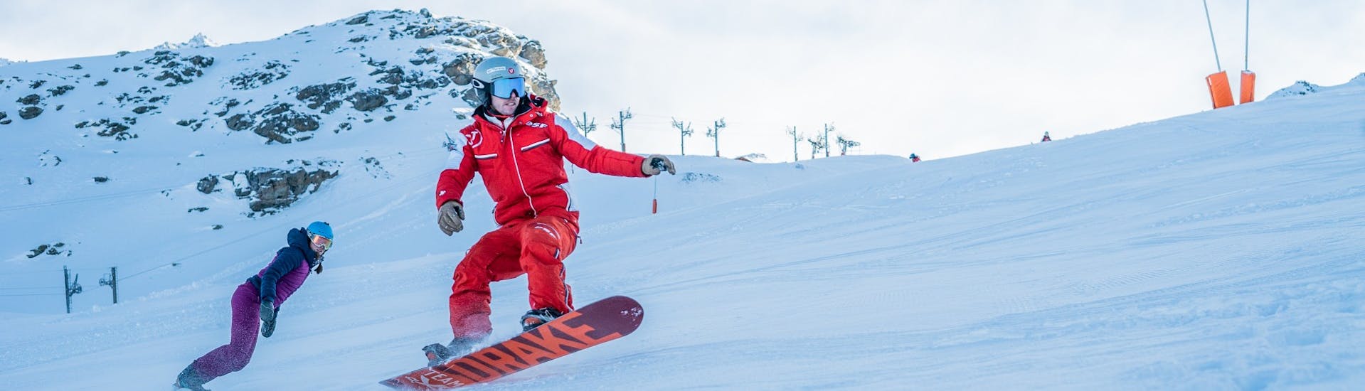 Ein Lehrer der ESF Val Thorens zeigt einige Tricks während eines privaten Snowboard-Kurses.