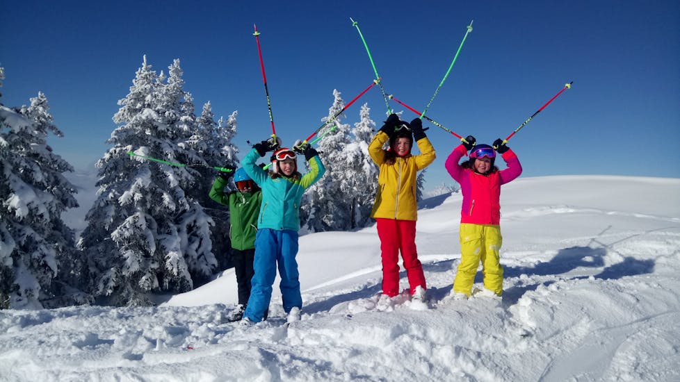 Kinderen in de sneeuw tijdens hun privé skilessen voor kinderen (vanaf 4 jaar) voor alle niveaus met de Skiart skischool in Kitzbühel.