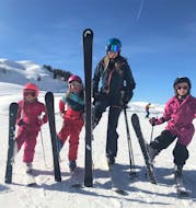 A ski instructor from Skiart Kitzbühel ski school with three children during her private ski lessons for kids (from 4 years) for all levels in Kitzbühel.