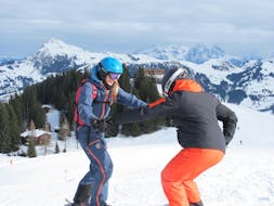 Eine Skilehrerin der Skischule Skiart Kitzbühel mit einem Schüler während die privaten Skikurses für Erwachsene für alle Levels in Kitzbühel.
