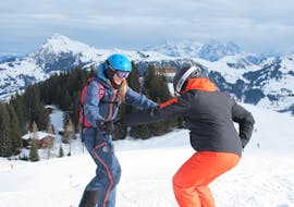 A ski instructor of the Skiart Kitzbühel ski school with a student during the private ski lessons for adults of all levels in Kitzbühel.