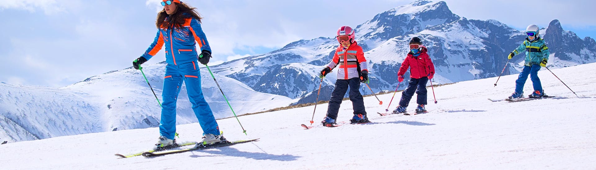 Kinderen volgen de ski-instructeur in Limone tijdens een van de Kinderskilessen voor Eerste Keer Skiën.
