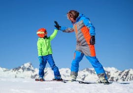 Un moniteur de ski avec un enfant à Limone pendant l'un des cours de ski pour enfants pour débutants.