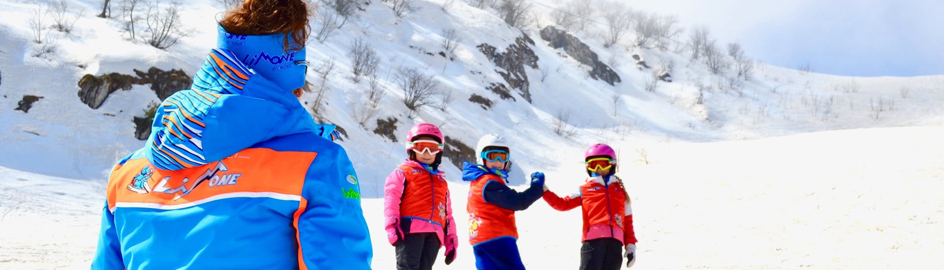 Ski-instructeur met blije kinderen in Limone tijdens een van de Kinderskilessen (vanaf 6 j.) voor Beginners.