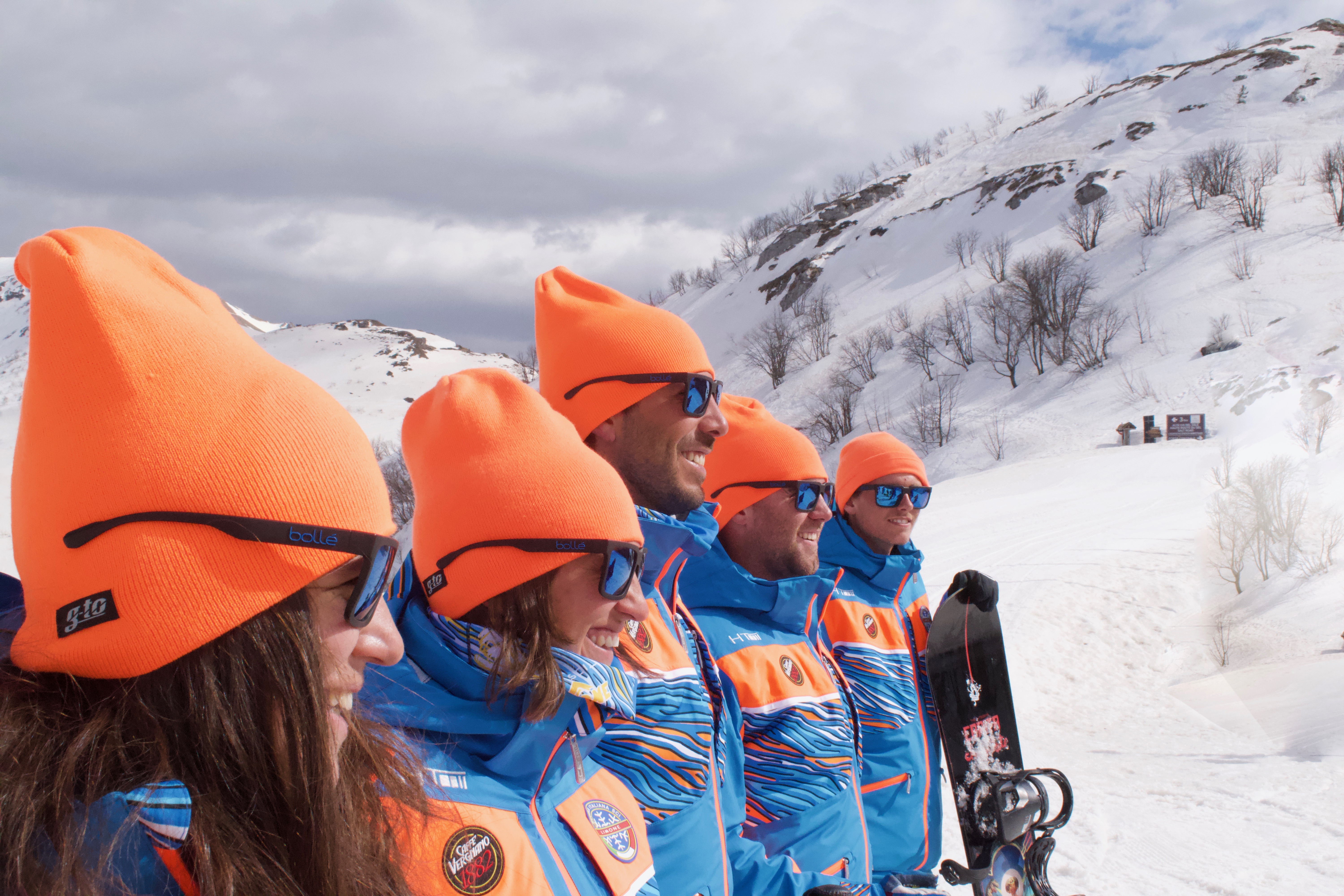 Ski instructors with sparkling orange hats in Limone getting ready for one of the Adults Ski Lessons for Beginners. 
