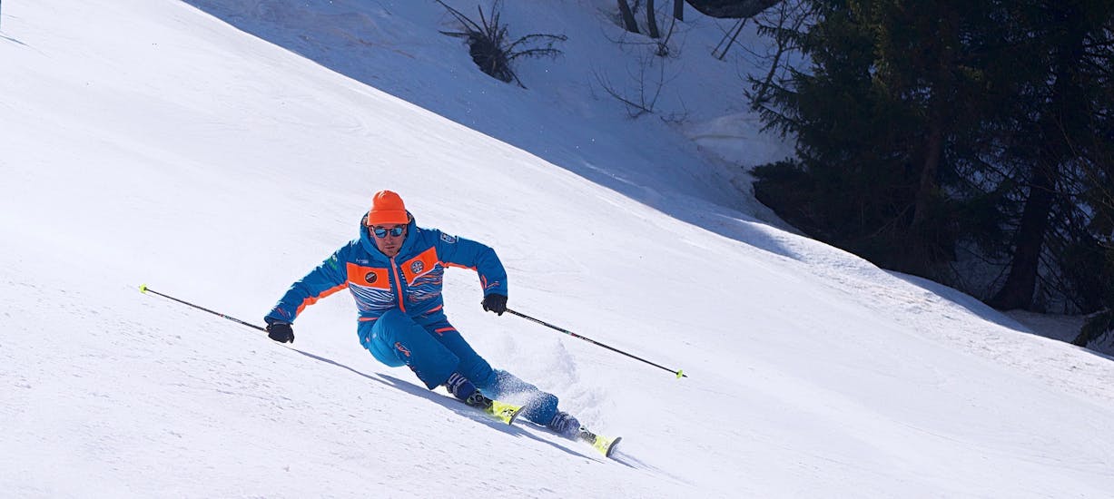 Maestro di sci che tira una curva a Limone dopo una delle lezioni di sci per adulti per sciatori avanzati.
