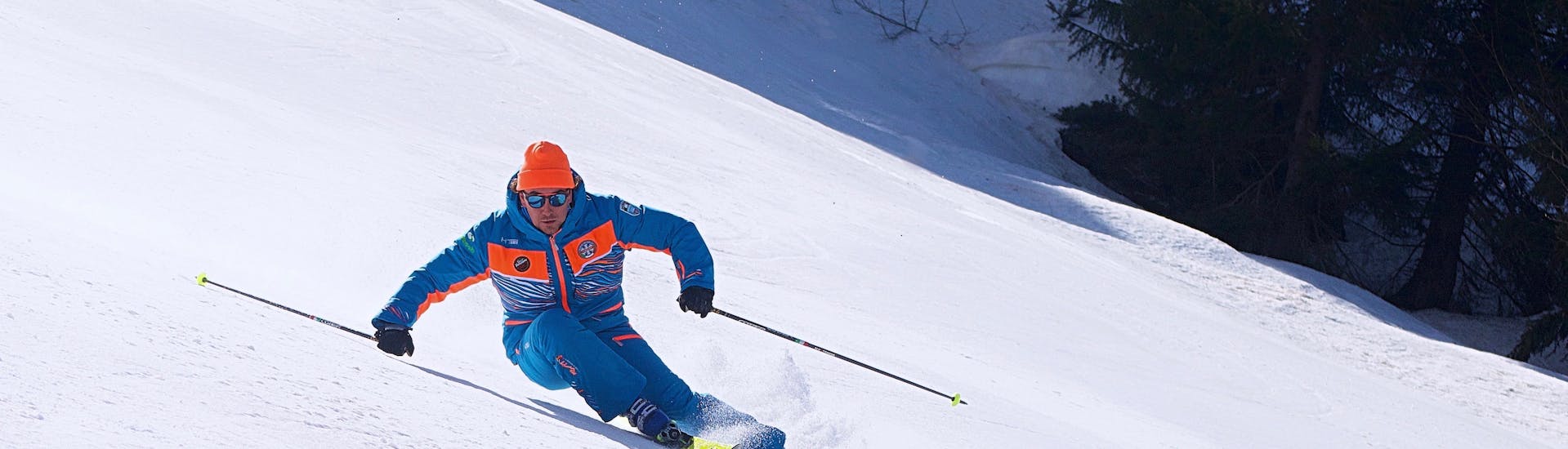 Maestro di sci che tira una curva a Limone dopo una delle lezioni di sci per adulti per sciatori avanzati.